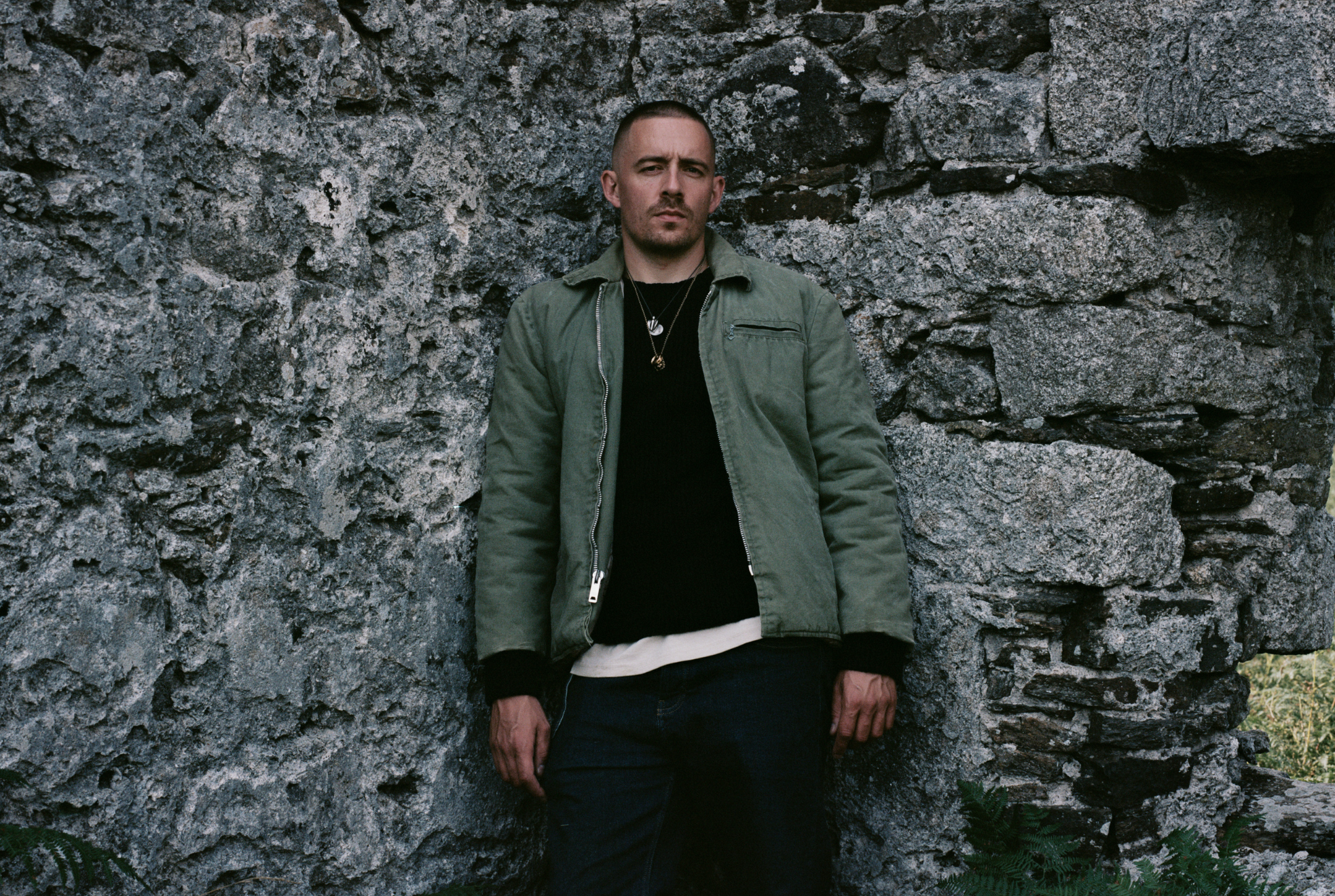 Dermot Kennedy leaning against a wall